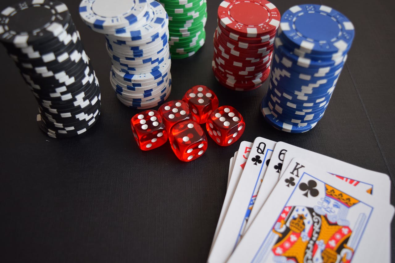 A vibrant display of casino chips, dice, and playing cards set on a table, embodying chance and excitement.